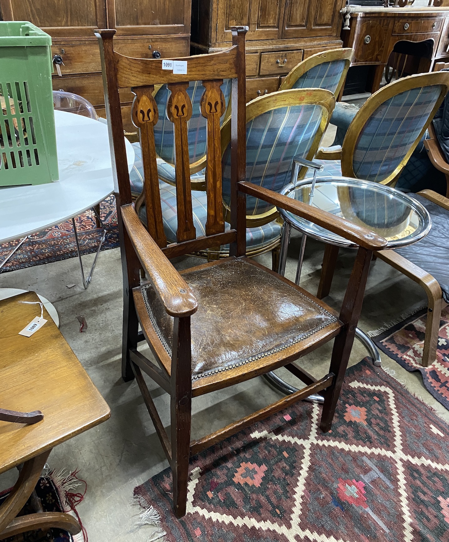 An Art Nouveau inlaid oak elbow chair, width 60cm, depth 52cm, height 114cm